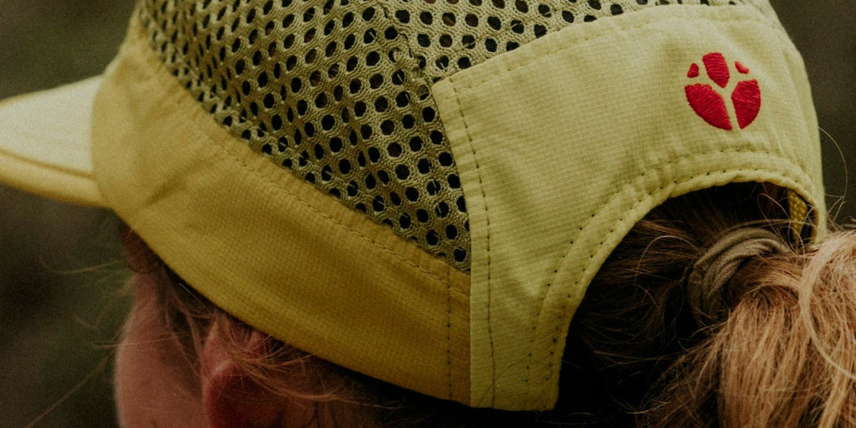 Close-up of a yellow Fractel running cap with large-hole flowmesh running fabric on the side panel