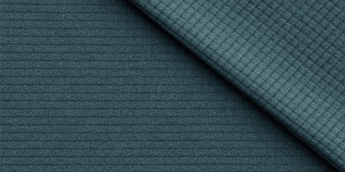 Close-up of teal Polartec Power Dry fabric with a ribbed and grid knit texture