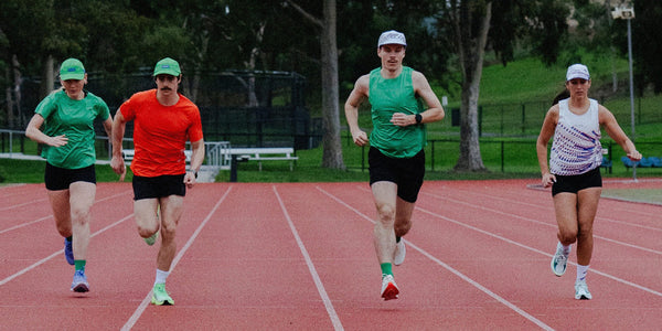 Four runners in Fractel velocity 3.0 running apparel sprinting along a red athletics track