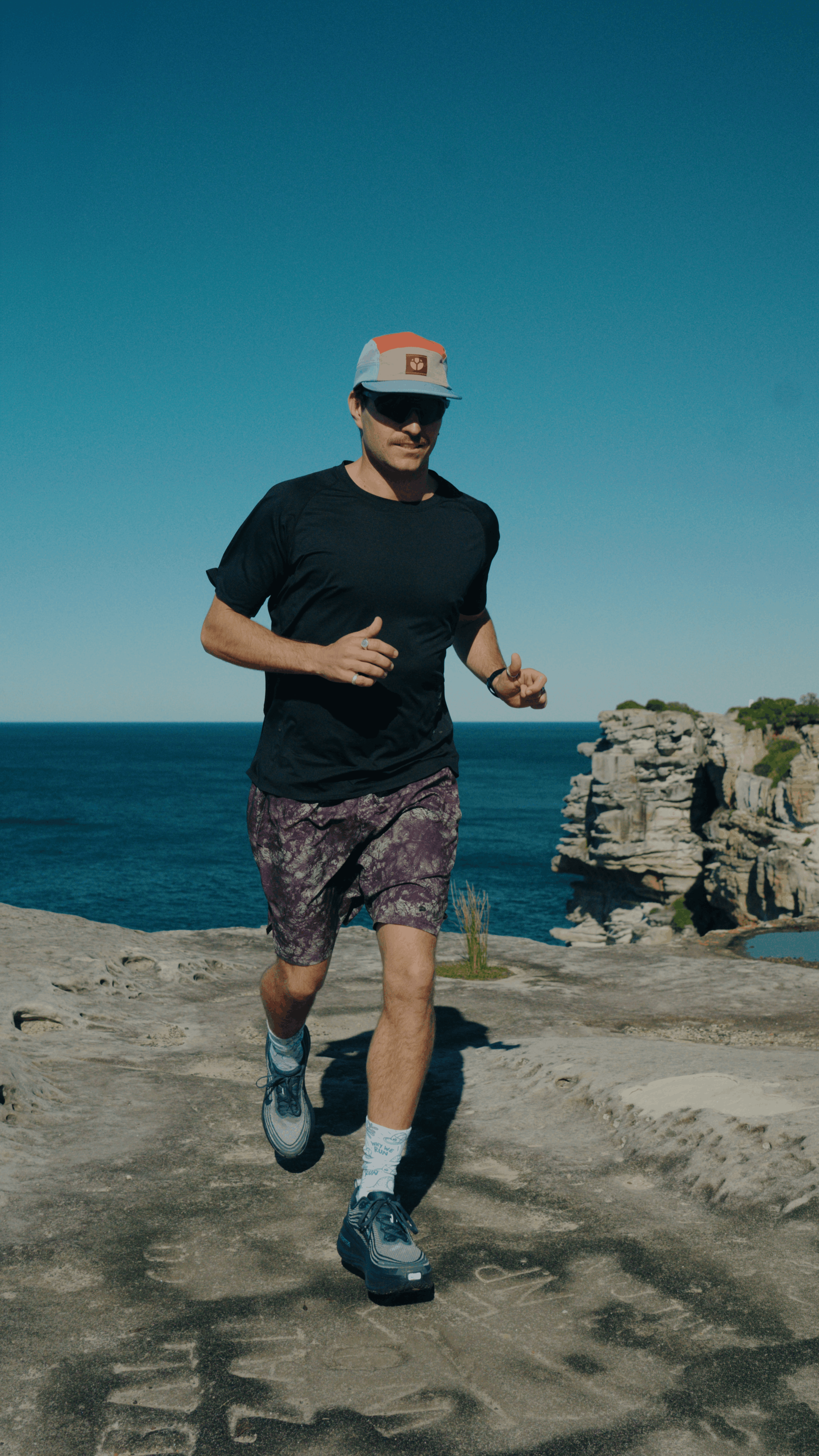 Lindsay running along a clifftop in Fractel's Q3 headwear range