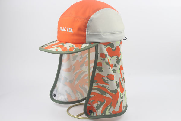 A Fractel legionnaire cap with a bright orange crown, light gray side panels, and a matching camouflage-print neck flap with a built-in metal ring stand.