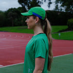 Female wearing a green cap and shirt on a track