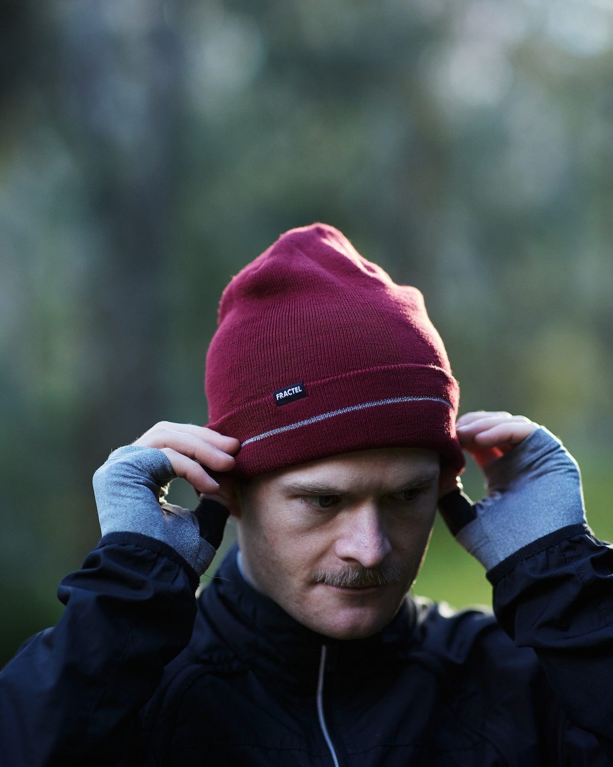 Burgundy merino wool running beanie with a Fractel tag and reflective stripe